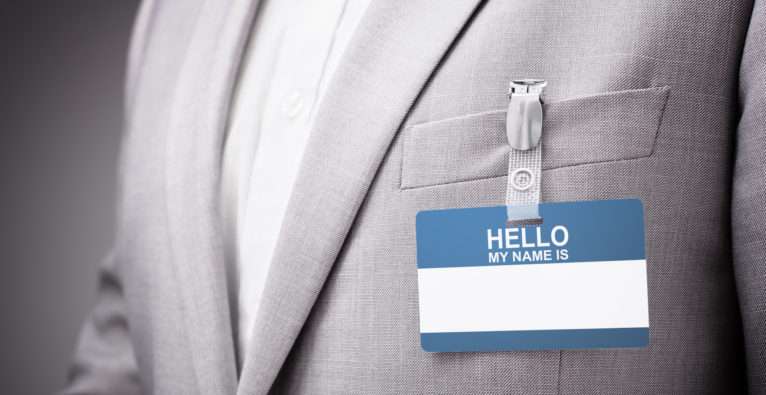 Businessman at an exhibition or conference wearing a Hello my name is security identity name card or tag