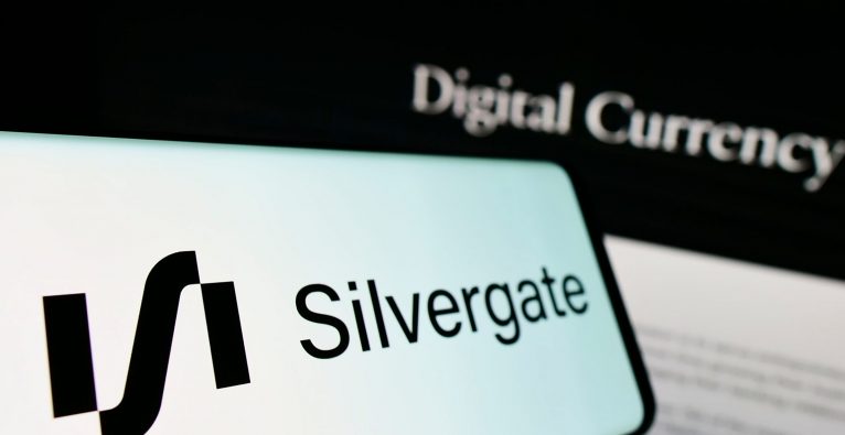 Cellphone with logo of American financial services company Silvergate Bank on screen in front of website. Focus on center-left of phone display