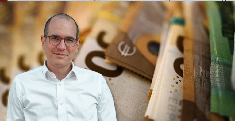 brutkasten-Kolumnist Niko Jilch vor Euro-Geldscheinen