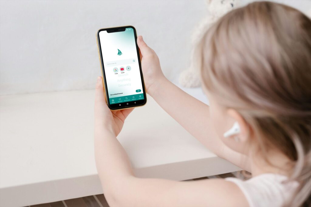 ein Kind hält ein Smartphone in der Hand, auf der der SilentSurf-Browser zu sehen ist