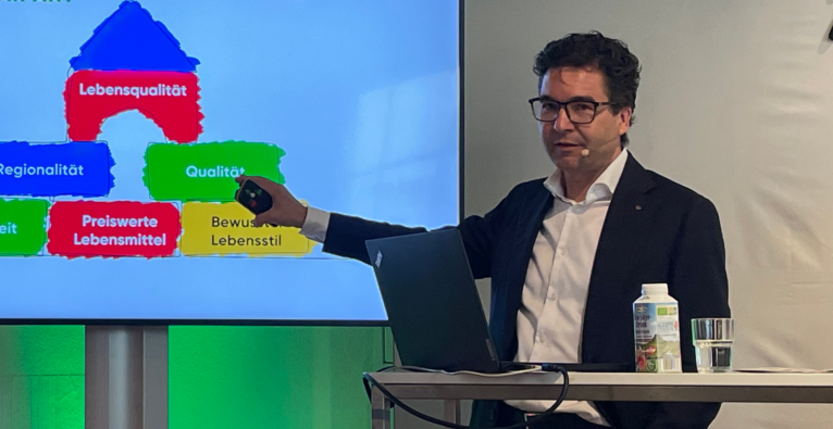 Markus Kaser, Stv. Vorstandsvorsitzender von Spar, zeigt auf einen Monitor und erklärt eine Grafik