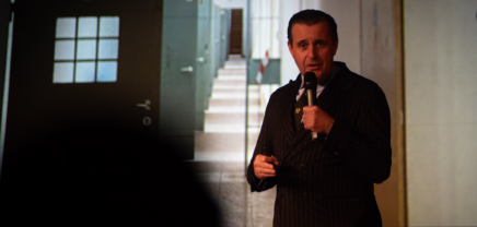 Chris Müller steht vor einer Präsentation und redet in ein Mikro. (c) Tobias Zachl