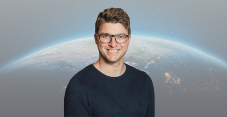 CEO von Terra Atmos Yannick Back lächelt in die Kamera. Im Hintergrund ist die Erdoberfläche zu sehen.